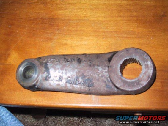 Rusty metal steering arm with splined opening and a smaller hole on the other end