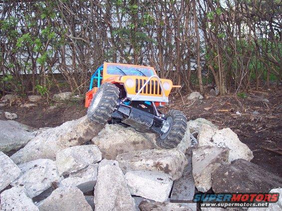 Orange remote control rock crawler on rocks