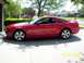 2006 Ford Mustang - Side view of a red 2006 Ford Mustang GT coupe with a spoiler.
