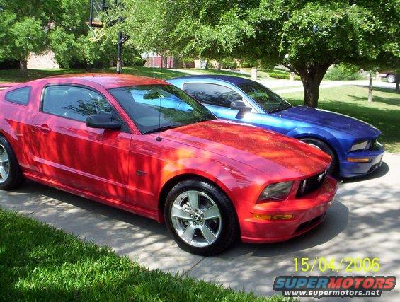 Red 2006 Ford Mustang GT parked next to a blue Mustang