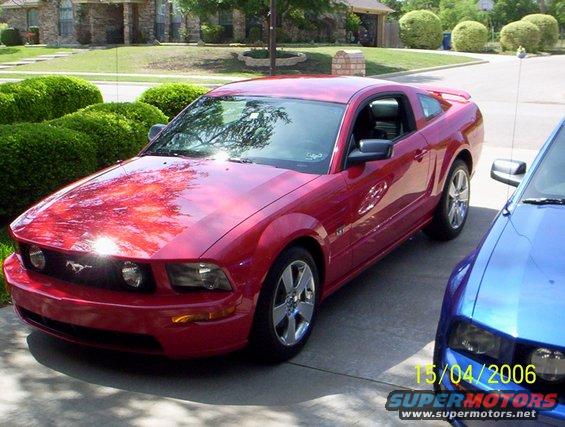 Red 2006 Ford Mustang parked next to a blue car