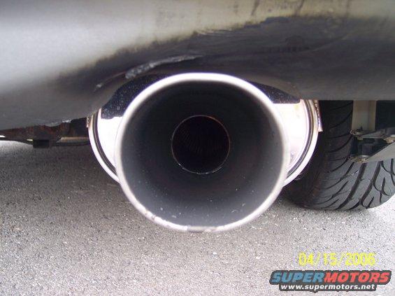 Exhaust pipe and tire of a vehicle, close-up view from below
