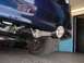 1993 Ford Taurus - Close-up view of a blue car's rear exhaust system, showing a Flowmaster muffler and a polished exhaust tip.