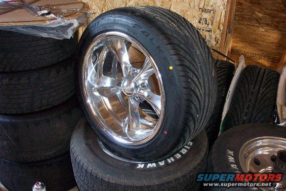 Chrome wheel with a performance tire stacked on other tires in a storage area
