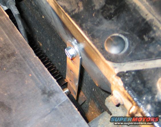 Metal bracket with bolt and gear teeth visible