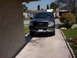 2006 Honda CR250R - Dark gray Ford F-150 pickup truck parked in a residential driveway.
