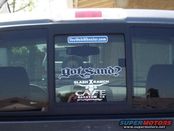 Truck rear window with stickers: 'got sand?', 'SLASH XRANCH', 'CAFE BARSTOW CA', and 'TheWebWheeler.com'