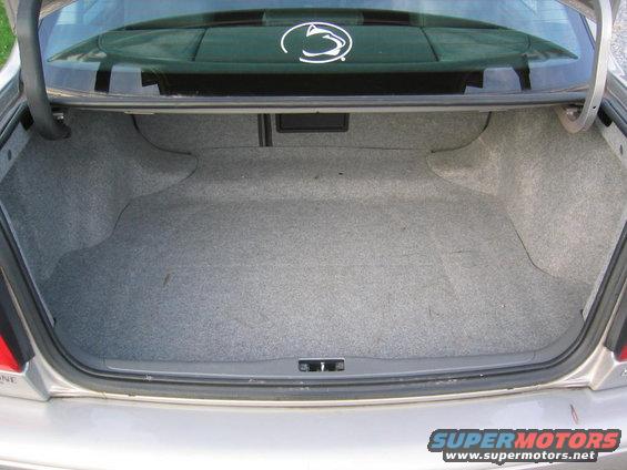 Open car trunk interior with gray carpet lining. Penn State logo sticker on rear window