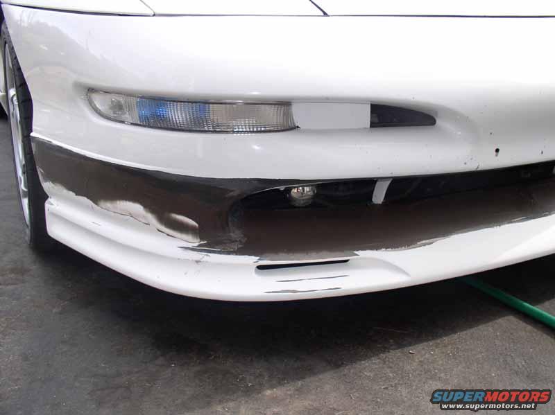 Front bumper of a white 1996 Ford Probe GT with black trim and some scuff marks