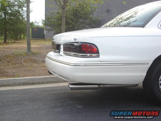 White 1995 Ford Crown Victoria sedan, rear quarter view, chrome trim, aftermarket exhaust pipe