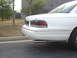 1995 Ford Crown Victoria - Rear view of a white 1995 Ford Crown Victoria sedan with tinted taillights and chrome trim.
