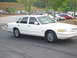 1995 Ford Crown Victoria - White 1995 Ford Crown Victoria sedan parked outdoors with other vehicles in background.