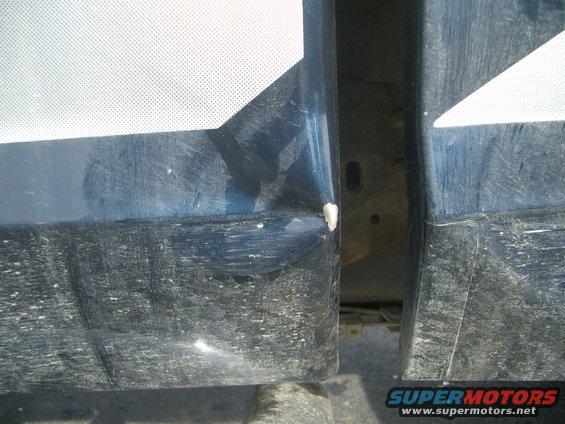 Blue truck door seam with dent and white graphic