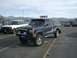 1992 Ford Ranger - A dark blue 1992 Ford Ranger pickup truck is parked in a lot with other vehicles and mountains in the background.