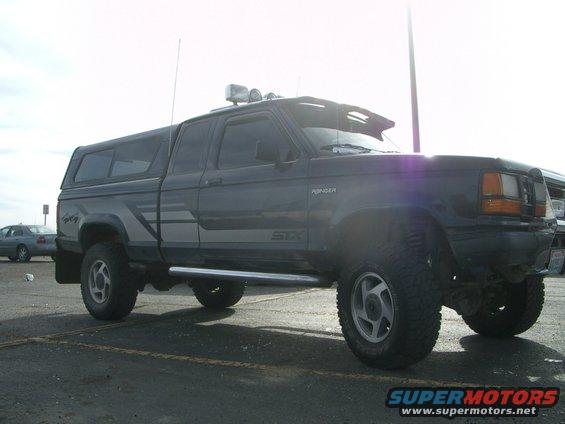 1992 Ford Ranger STX pickup truck with camper shell, lifted suspension, and off-road tires
