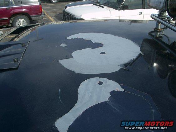 Dark blue car roof with peeling paint patches and a chrome light fixture