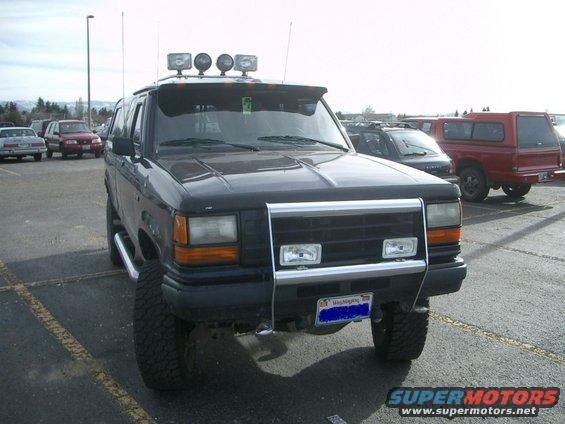 Black Ford Explorer with aftermarket grille guard and roof lights