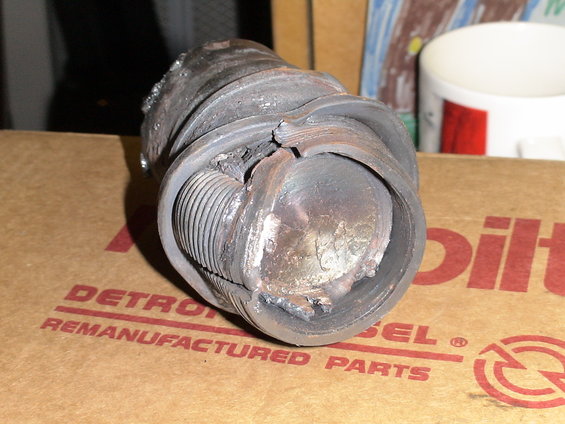 Damaged threaded metal part on Detroit Diesel remanufactured parts box