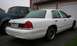 1998 Ford Crown Victoria - Rear view of a white 1998 Ford Crown Victoria parked in front of a garage.
