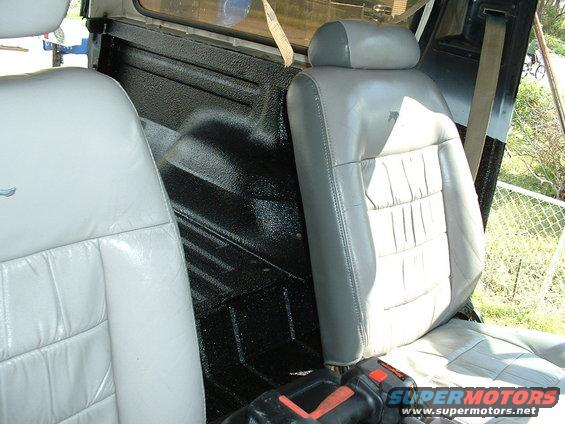 Interior view showing light gray front seats and black textured rear cargo area