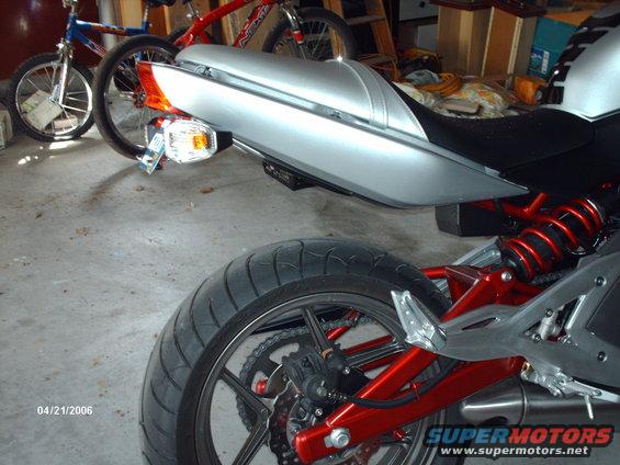Silver motorcycle rear with red suspension and black tire. Date stamp 04/21/2006