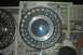 1991 Ford Crown Victoria LTD - A single Ford hubcap is shown against a backdrop of old newspapers.