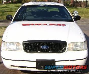 White 1999 Ford Crown Victoria police car front view with 'WHELEN' text on hood