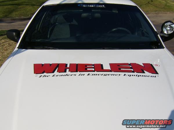 White car hood with red "WHELEN" lettering and "The Leaders in Emergency Equipment" text below