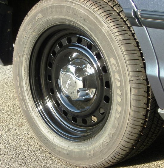 Close-up of a black steel wheel with a chrome hubcap and Goodyear tire