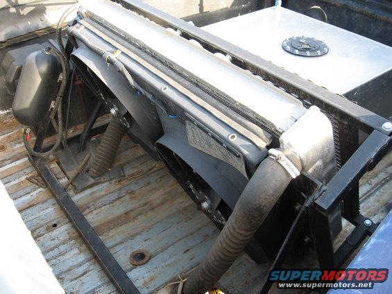 Radiator and fan assembly mounted in a truck bed with a fuel tank behind it