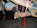 1996 Ford Bronco - Close-up view of a vehicle's undercarriage, focusing on the driveshaft and suspension components supported by jack stands.