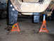 1996 Ford Bronco - Vehicle underbody components, including a lift kit, are visible while the vehicle is supported by jack stands.