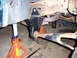 1996 Ford Bronco - Close-up view of vehicle suspension components, including a lift bracket and jack stands.