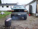 1996 Ford Bronco - A lifted green Ford Bronco is parked in a driveway, emitting smoke from its exhaust.