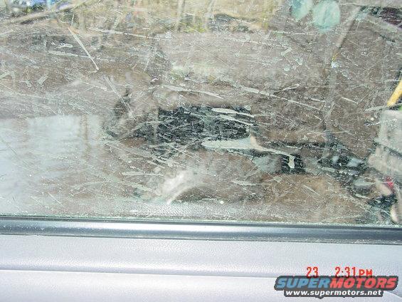 View through a cracked and dirty windshield showing debris and reflections