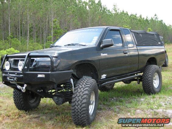 Black lifted pickup truck with off-road tires and brush guard