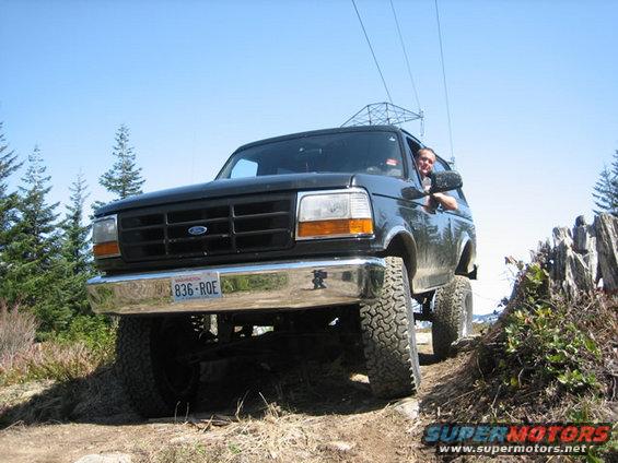 Black 1995 Ford Bronco driving off-road on a sunny day