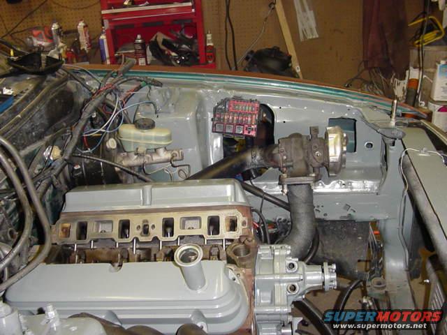 Engine bay with a turbocharger installed, brake fluid reservoir, and fuse box visible