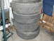 1979 Ford Bronco - A stack of four used tires are stored indoors.