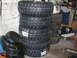 1979 Ford Bronco - A stack of four new off-road tires sits next to other used tires and a winch.