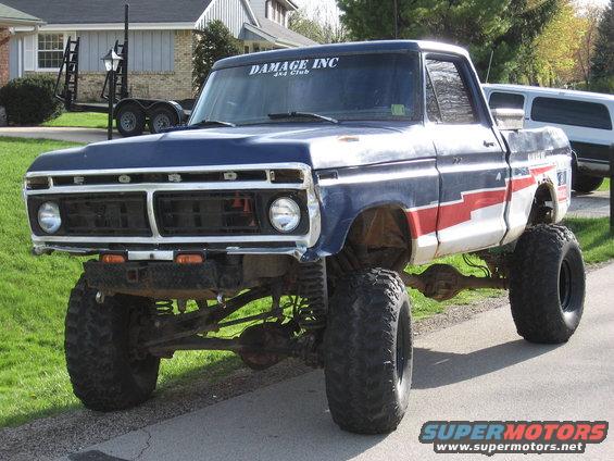 Blue and red 1977 Ford F-150 pickup truck with lifted suspension and large tires, parked on a street