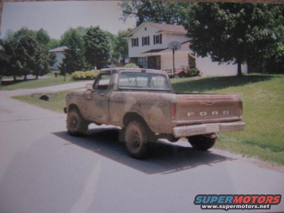 Brown 1977 Ford F-150 pickup truck, rear 3/4 view, dusty condition, parked on asphalt