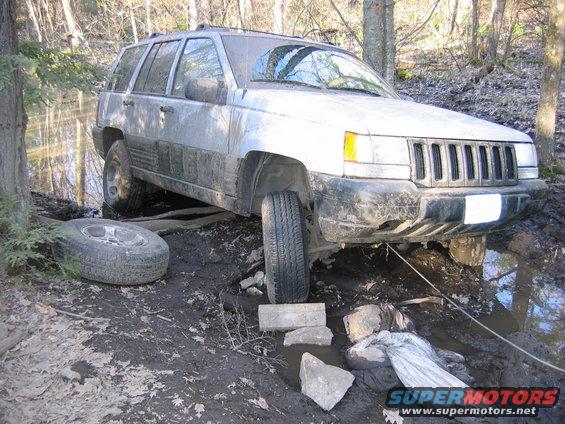 spare tire to the left and wood under the tire