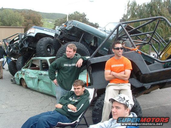 Stacked off-road vehicles on a car with people