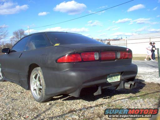 Black coupe with dual exhaust pipes and a green license plate