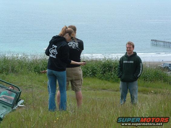 Green Jeep YJ parked on grassy hill overlooking ocean
