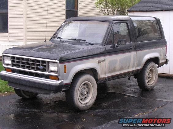 1988 Ford Bronco II parked on wet pavement in front of a house