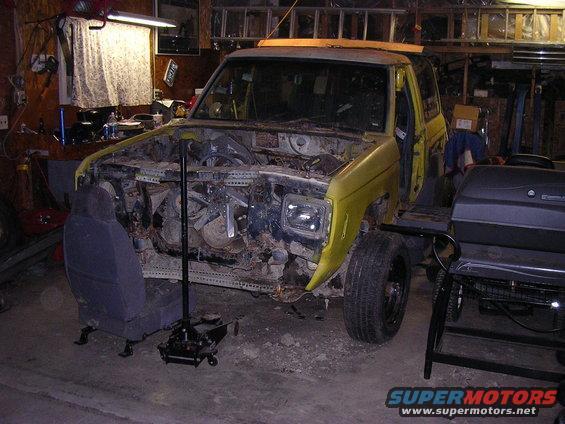1987 Ford Bronco II disassembled in garage with engine bay open, seat removed