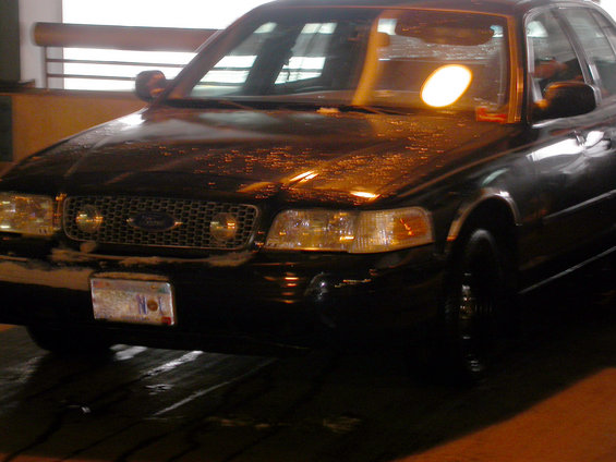 Front view of a black 2001 Ford Crown Victoria with a license plate
