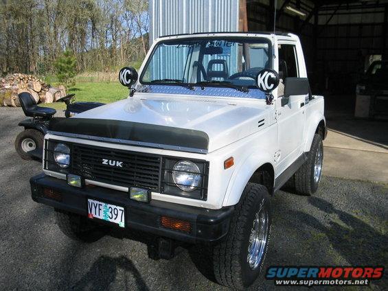 White 1987 Suzuki Samurai with KC lights and custom grille